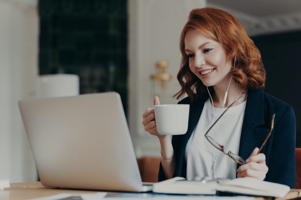 Intelligent female student has online course, concentrated in screen of laptop computer